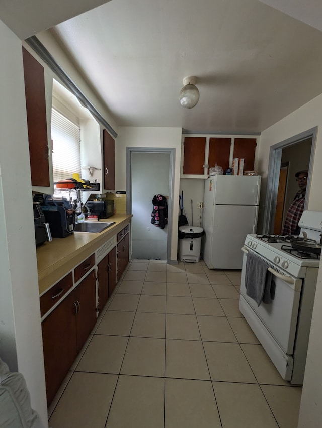 7661 Penrod St, Detroit, MI 48228 - kitchen with light countertops, light tile patterned floors, a sink, and white appliances