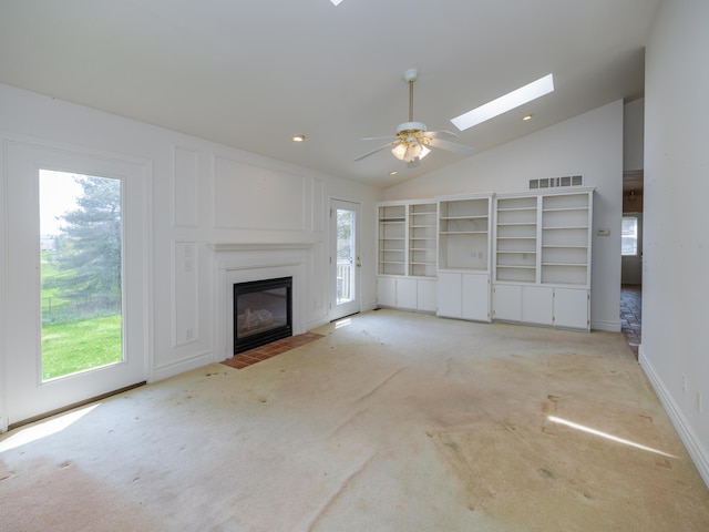 6273 S 12th St, Portage, MI 49024 - unfurnished living room featuring vaulted ceiling with skylight, light colored carpet, a fireplace with flush hearth, and a healthy amount of sunlight