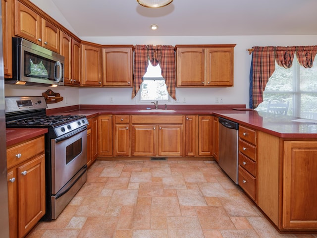 6273 S 12th St, Portage, MI 49024 - kitchen with a sink, appliances with stainless steel finishes, brown cabinetry, and a peninsula