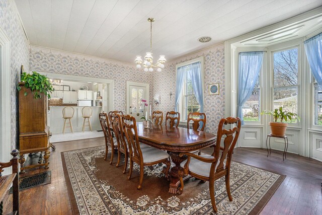 204 E Burr Oak St, Centreville, MI 49032 - dining area featuring wallpapered walls, crown molding, dark wood-style flooring, and an inviting chandelier