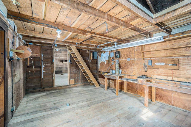 204 E Burr Oak St, Centreville, MI 49032 - below grade area featuring wooden walls, a workshop area, and hardwood / wood-style flooring