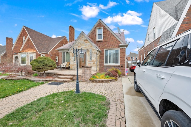 view of front of house with a chimney and brick siding