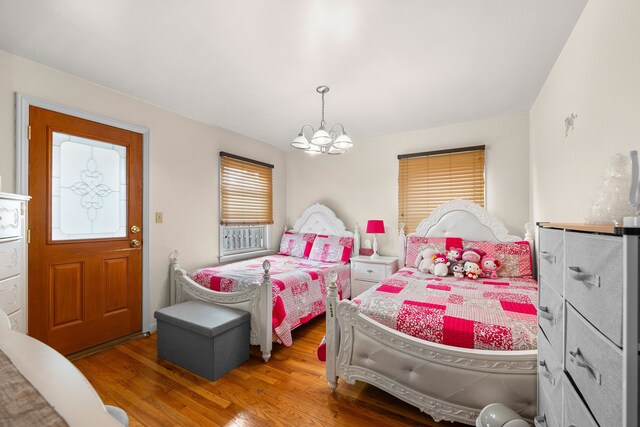 bedroom featuring wood finished floors and an inviting chandelier