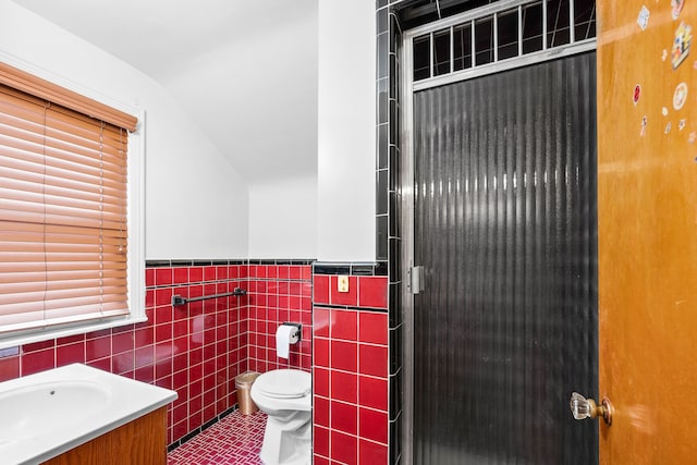 bathroom featuring toilet, tile walls, tile patterned flooring, a shower stall, and vanity