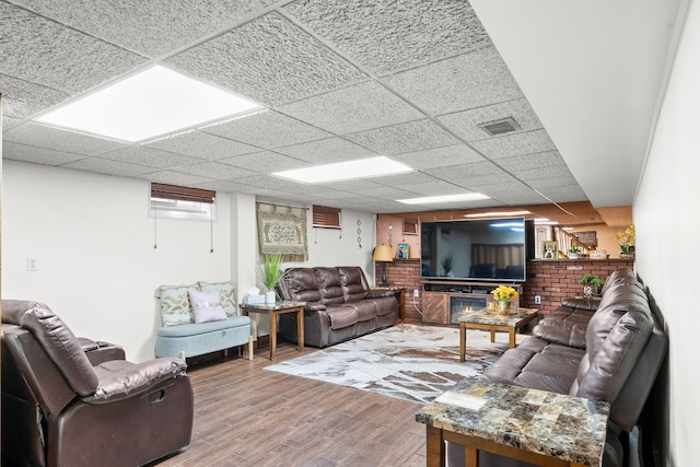 living room featuring wood finished floors, visible vents, and a drop ceiling