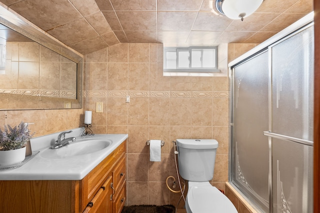 full bath featuring a shower stall, tile walls, toilet, and vanity
