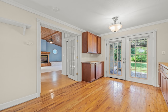 2316 Sugar Riv, Gladwin, MI 48624 - kitchen with light wood-style floors, light countertops, a fireplace with raised hearth, and french doors