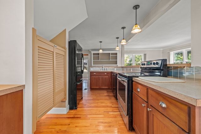2316 Sugar Riv, Gladwin, MI 48624 - kitchen with brown cabinetry, a sink, light countertops, black appliances, and light wood-style floors