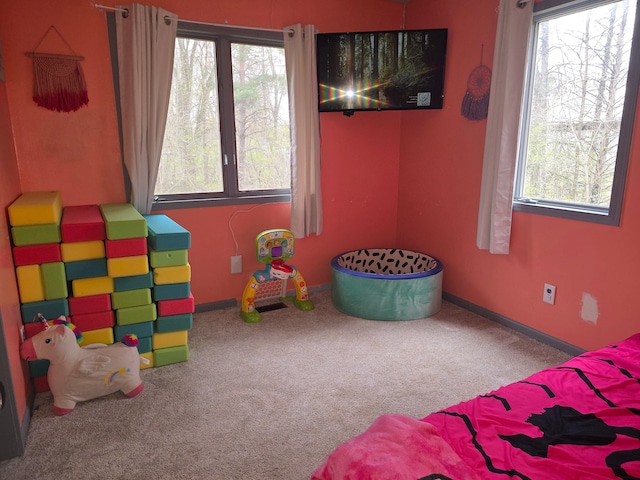 carpeted bedroom with multiple windows and baseboards