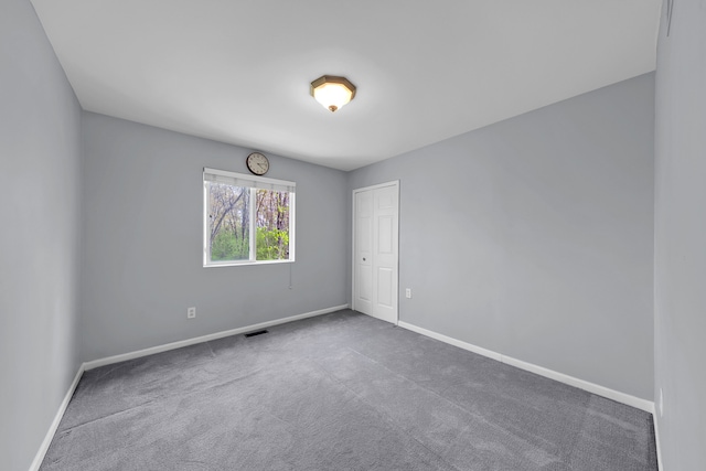 empty room featuring baseboards, carpet flooring, and visible vents