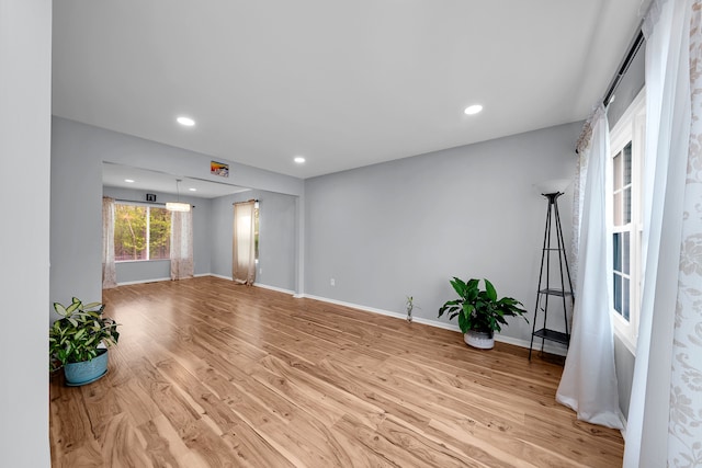 unfurnished living room with recessed lighting, baseboards, and wood finished floors