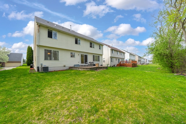 rear view of house featuring a yard, a patio, and a wooden deck