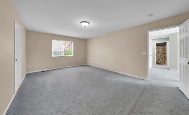 empty room with baseboards and carpet