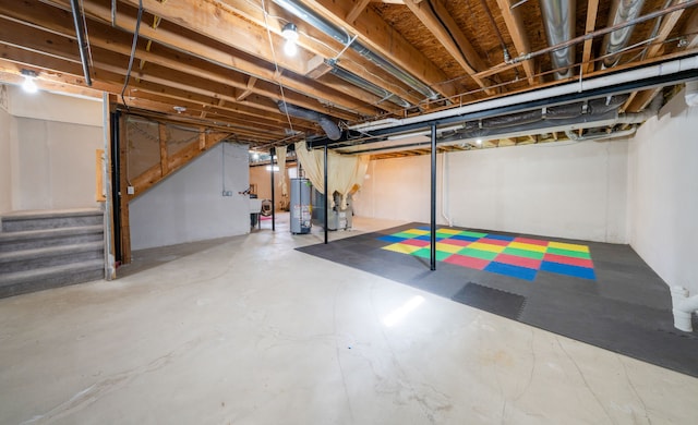 unfinished basement with gas water heater and stairway