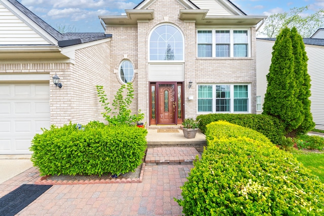 entrance to property featuring brick siding and a garage