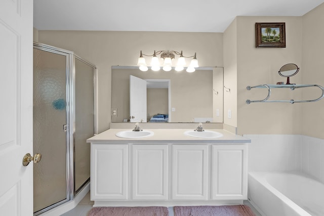 bathroom with a sink, double vanity, a shower stall, and a bath