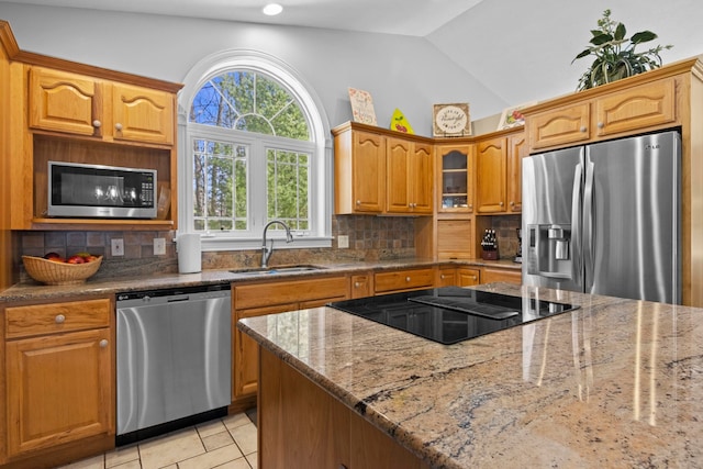 9681 Sugar Bush Run, Traverse City, MI 49685 - kitchen with stainless steel appliances, backsplash, light stone counters, and a sink