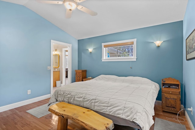 9681 Sugar Bush Run, Traverse City, MI 49685 - bedroom featuring lofted ceiling, ceiling fan, baseboards, wood finished floors, and ensuite bath