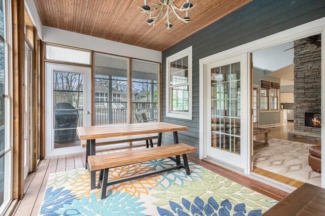 sunroom / solarium with an inviting chandelier, hardwood / wood-style floors, and plenty of natural light