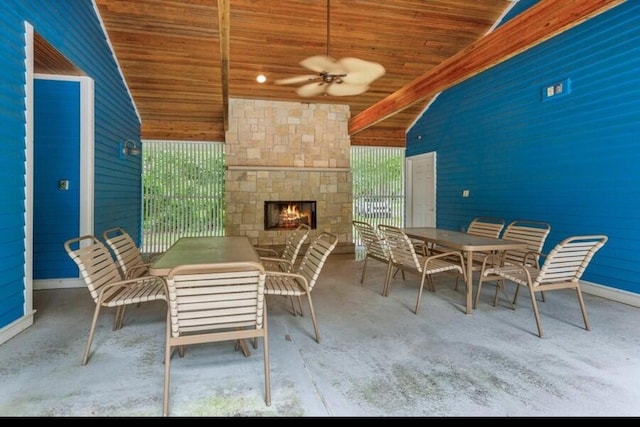 view of patio / terrace with an outdoor stone fireplace, a ceiling fan, and outdoor dining area