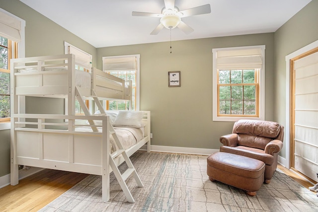 bedroom featuring wood finished floors, a ceiling fan, and baseboards