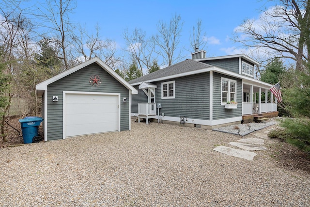 view of property exterior featuring a chimney, a shingled roof, an outdoor structure, a detached garage, and a porch