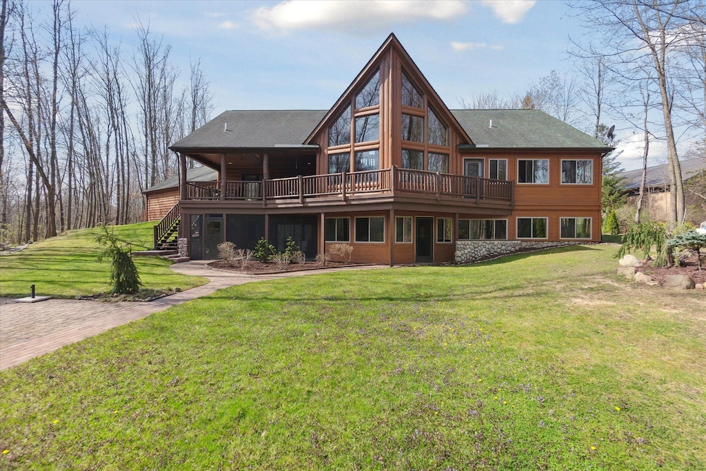 back of property with stairway, a yard, a shingled roof, and a wooden deck