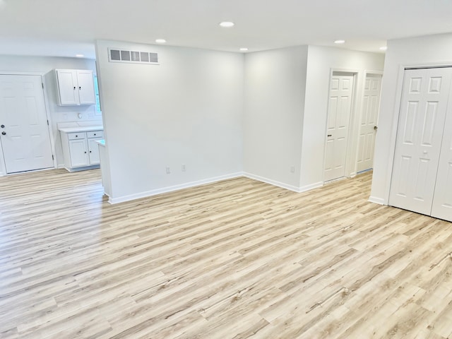 spare room with baseboards, visible vents, recessed lighting, and light wood-style floors