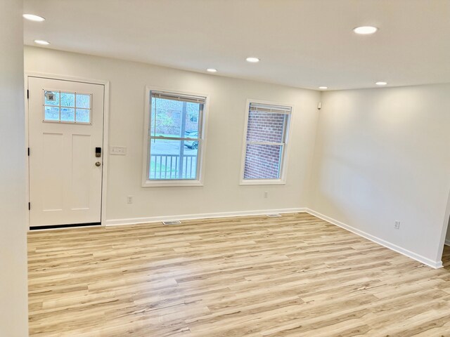 foyer featuring baseboards, recessed lighting, and light wood-style floors