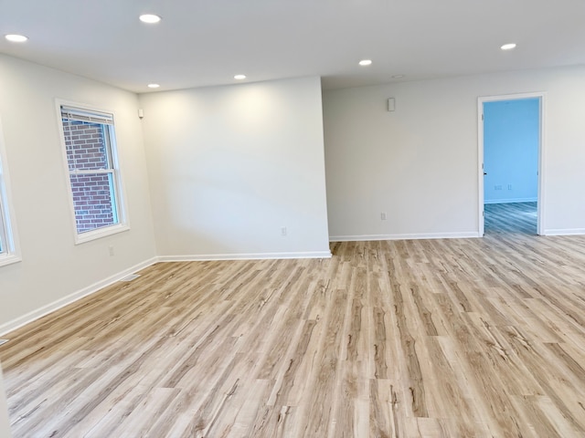 unfurnished room featuring recessed lighting, light wood finished floors, and baseboards