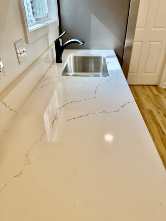 room details with light stone counters and a sink