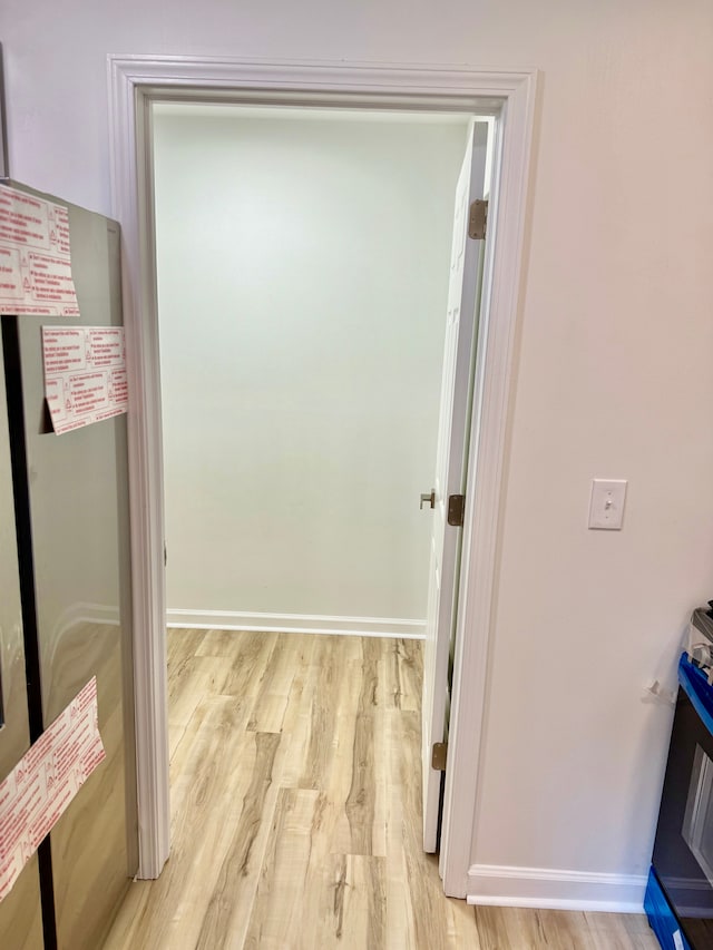hallway featuring baseboards and light wood-style floors