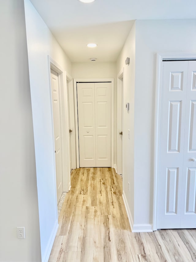 hallway with baseboards and light wood-type flooring