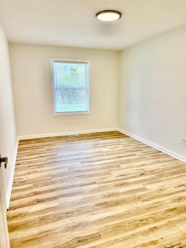 unfurnished room with wood finished floors and baseboards