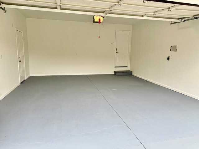 garage with baseboards and a garage door opener