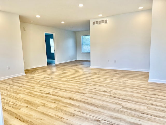 spare room featuring baseboards, light wood-style floors, visible vents, and recessed lighting