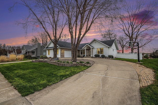 5591 Pioneer Ave, Saint Joseph, MI 49085 - view of front of property featuring a front lawn, fence, an attached garage, and curved driveway