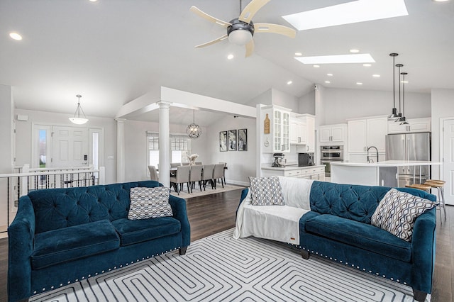 5591 Pioneer Ave, Saint Joseph, MI 49085 - living area featuring lofted ceiling with skylight, decorative columns, baseboards, a ceiling fan, and dark wood-type flooring
