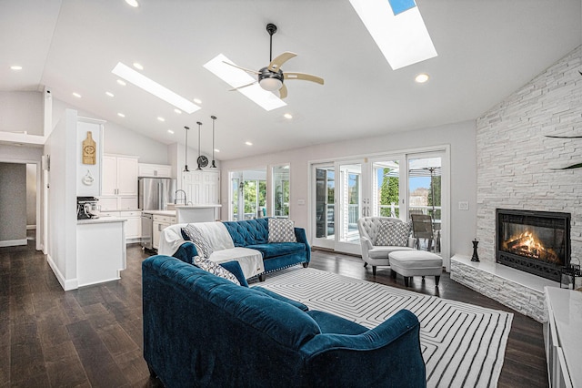 5591 Pioneer Ave, Saint Joseph, MI 49085 - living room with high vaulted ceiling, dark wood-style flooring, a stone fireplace, and a skylight