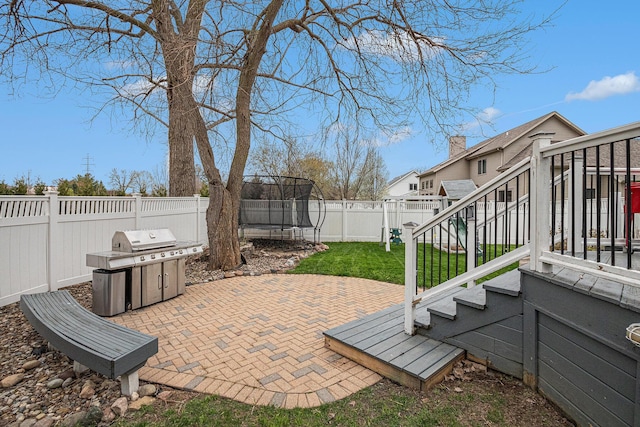 5591 Pioneer Ave, Saint Joseph, MI 49085 - view of patio / terrace with stairway, a fenced backyard, a grill, and a trampoline