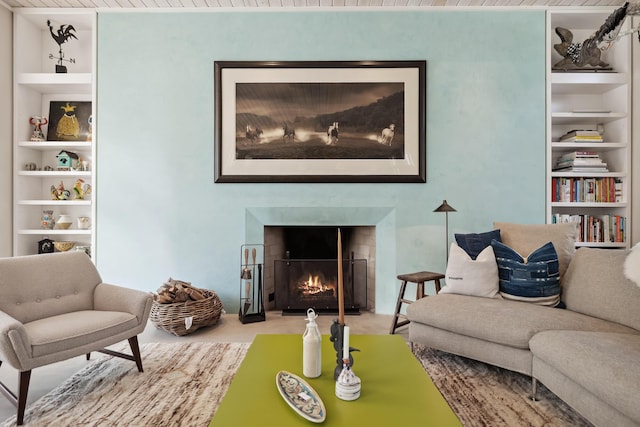 living room with built in features and a warm lit fireplace