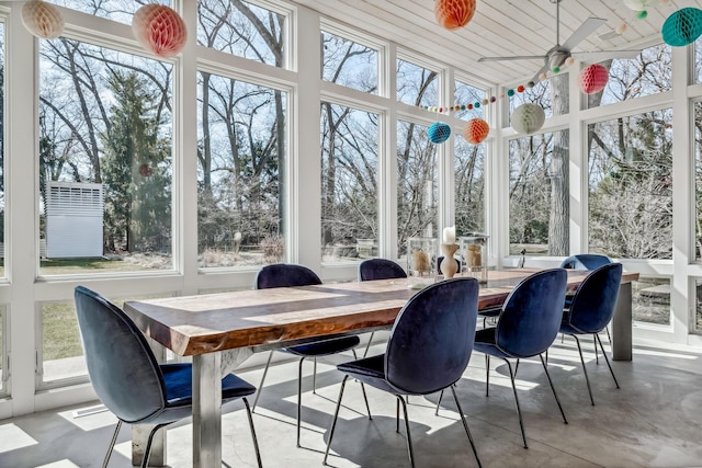 sunroom / solarium with a towering ceiling and finished concrete flooring
