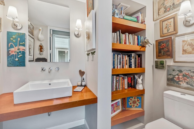 half bath featuring toilet and a sink