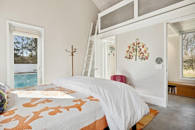 bedroom featuring baseboards, concrete flooring, and multiple windows