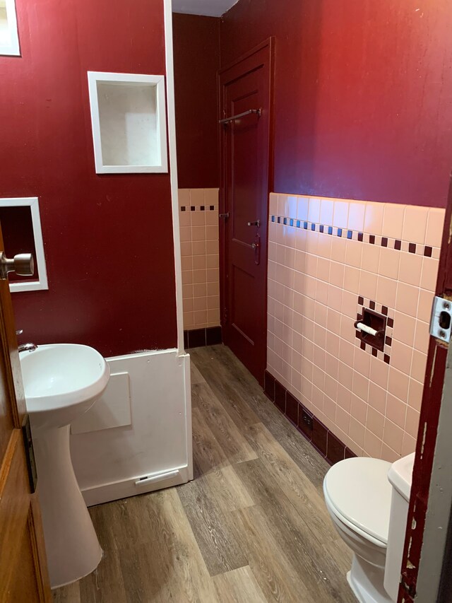 802 Dupont St, Flint, MI 48504 - bathroom with toilet, a wainscoted wall, wood finished floors, and tile walls