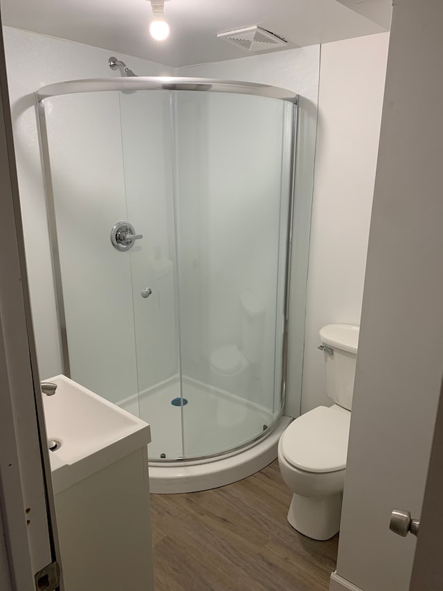 802 Dupont St, Flint, MI 48504 - full bathroom with toilet, visible vents, wood finished floors, a shower stall, and vanity