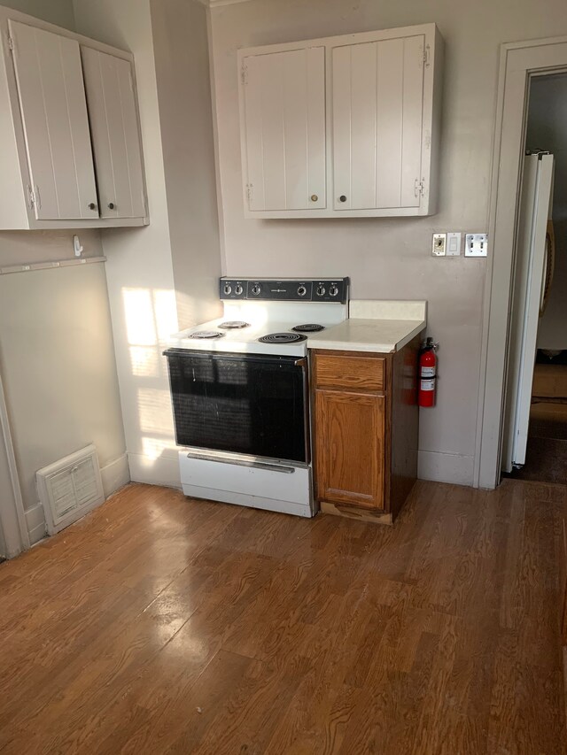 802 Dupont St, Flint, MI 48504 - kitchen with white electric range oven, fridge, visible vents, baseboards, and wood finished floors