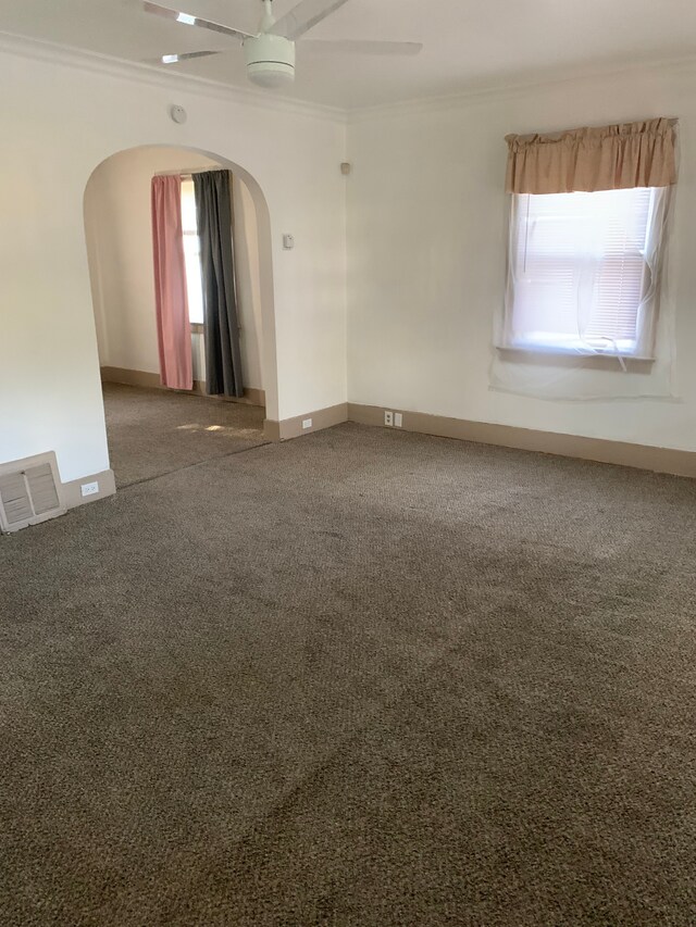 802 Dupont St, Flint, MI 48504 - spare room with a ceiling fan, arched walkways, crown molding, and visible vents