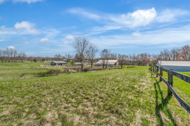 view of yard featuring fence and a rural view