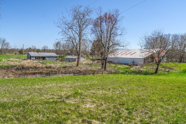 view of yard with a rural view and an outbuilding